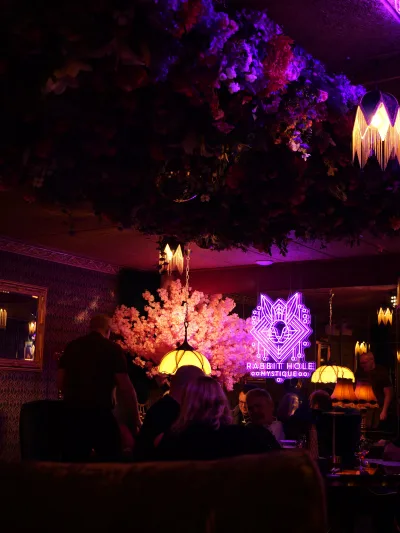 Bar med neonskilt og blomsterloft